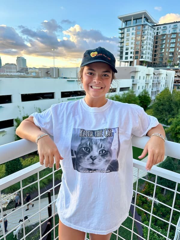 smiling girl with her Keith the Cat shirt and hat