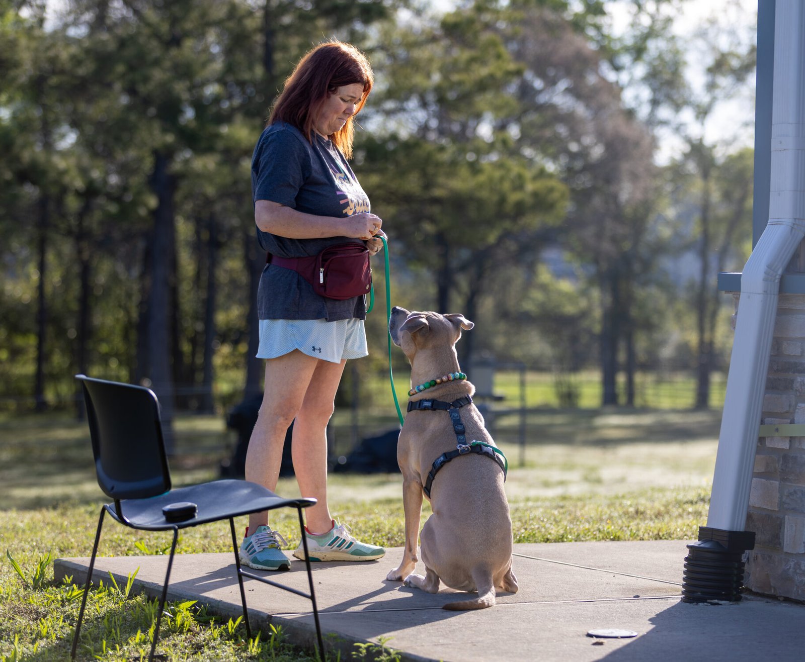 Holly with her dog Gracie who is sitting, looking up at her.